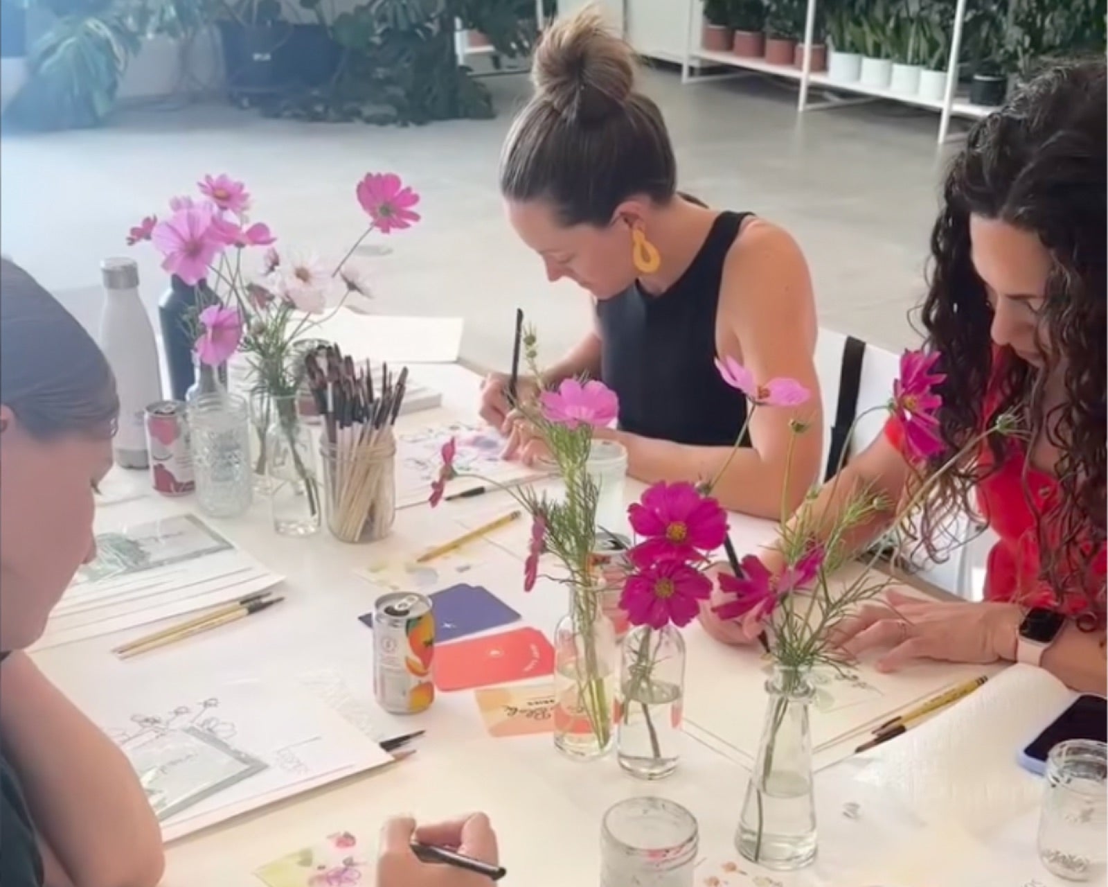 Two people quietly sharing their doodled cards at a small table