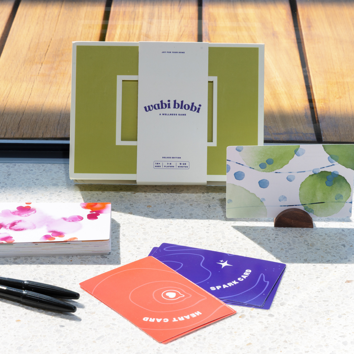 Wabi Blobi Deluxe Edition box with blob postcards, prompt cards and pens on a table