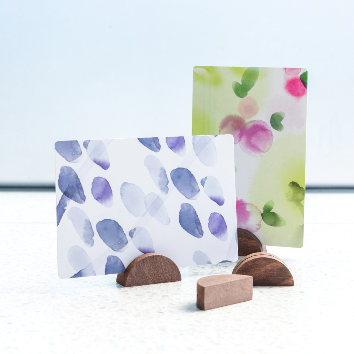 Wooden display stands holding watercolor blob postcards